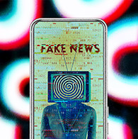 A cellphone has a person with a TV in place of their head and the words FAKE NEWS showing on screen.