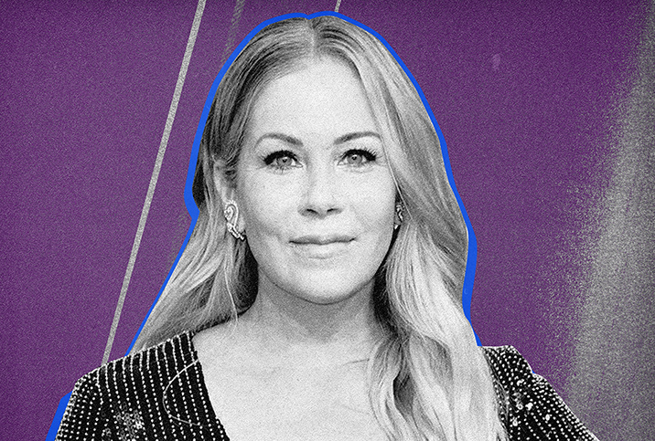 Christina Applegate poses for a camera at an event against a purple background.
