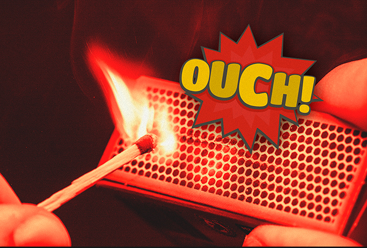 A match strikes off of a matchbox with the word OUCH in a spiked bubble above it.