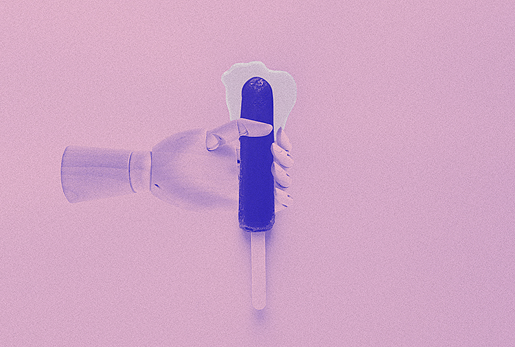 A pink robotic hand holds a blue popsicle on a stick as a clear white liquid puddles at the tip.