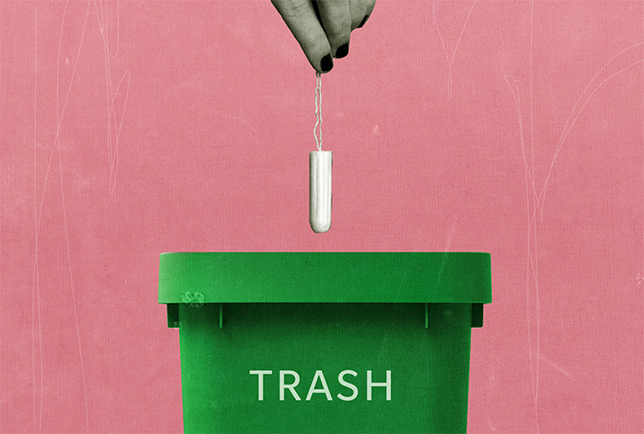 A grey hand drops a tampon into a green trash can against a pink background.