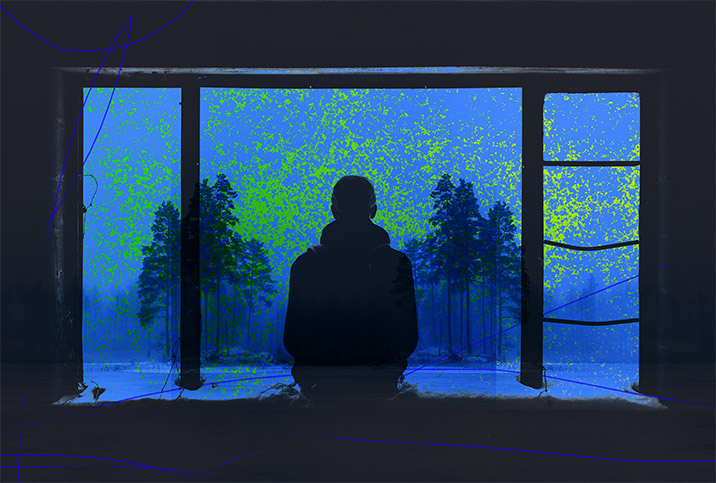 A person looks through a window to a wintery forest outside under a foggy blue light.