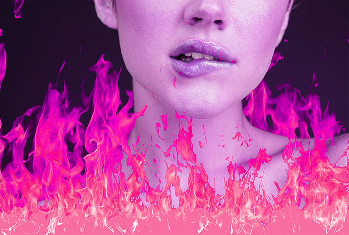 A woman bites her lower lip as pink and coral flames surround her shoulders.