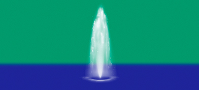 A fountain shoots water upwards in the middle of blue water against a green background.