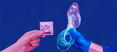 One hand holds a condom out towards another hand covered in a blue glove holding a breathing mask and tube.