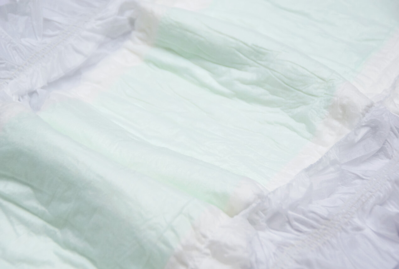 A close up shot shows the inside of an adult diaper.