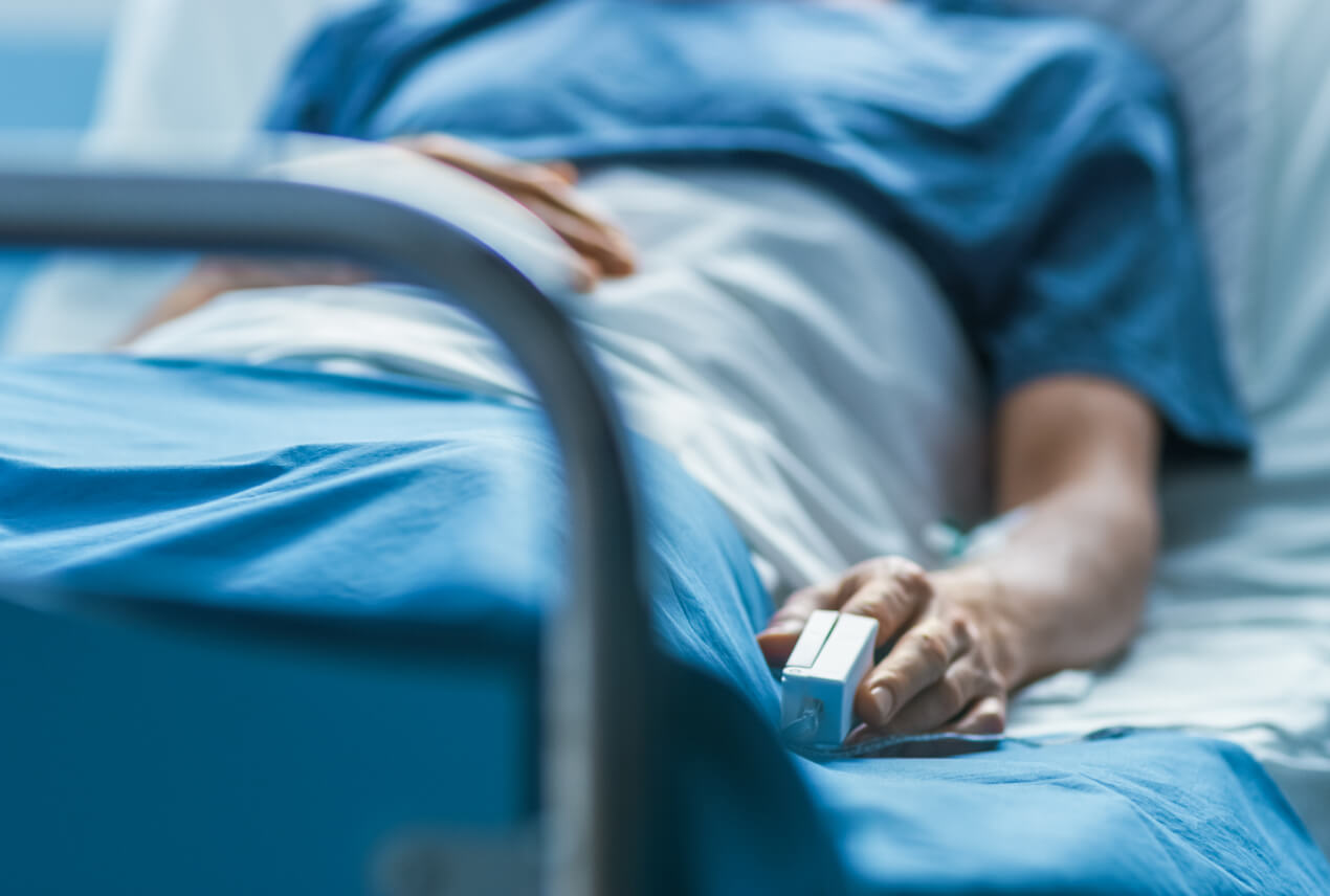 A person lays in a hospital bed.