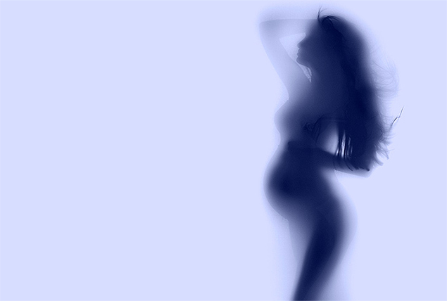 The dark silhouette of a pregnant woman is behind a frosted wall.