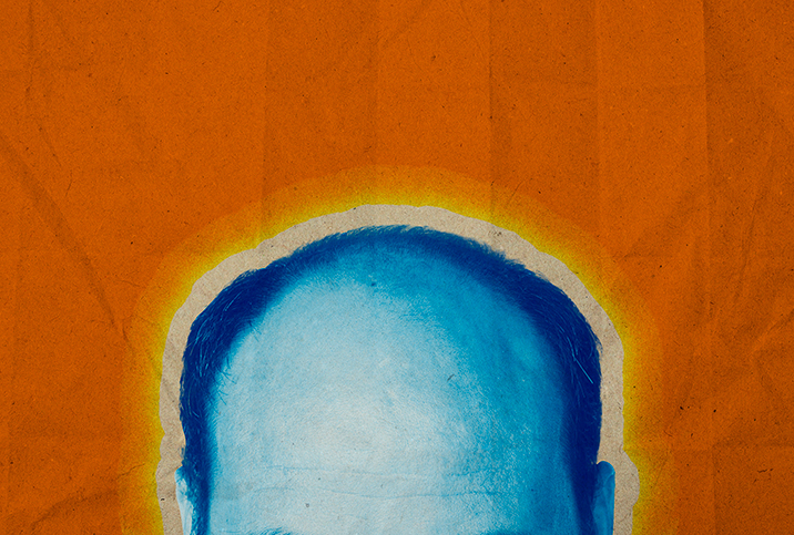 The top of a balding, blue head is in front of an orange background.