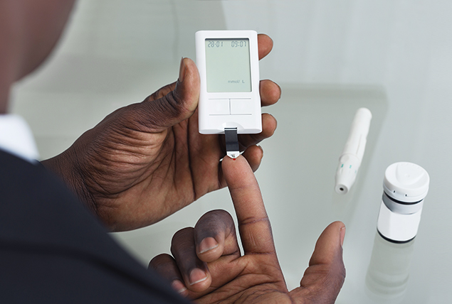 A man uses a glucose monitor to test his blood sugar.