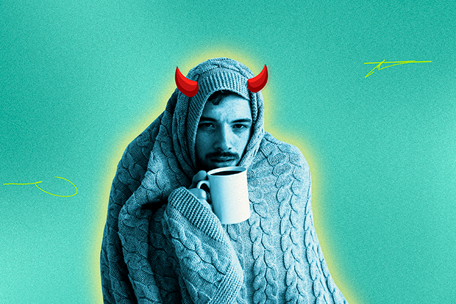 A man is wrapped up in a blanket with a mug of tea in his hand while horns grow from his forehead.