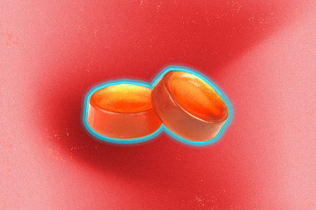 A pair of gummies sit against a red background.