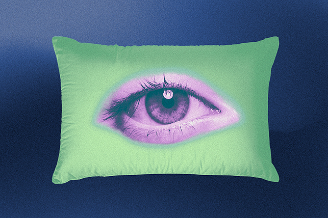 An open eye is in the middle of a green pillow.