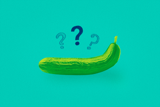 A cucumber curves upwards as it lays against a teal background with three question marks over it.