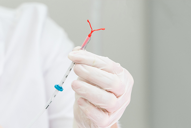 A doctor holds an IUD to be inserted.