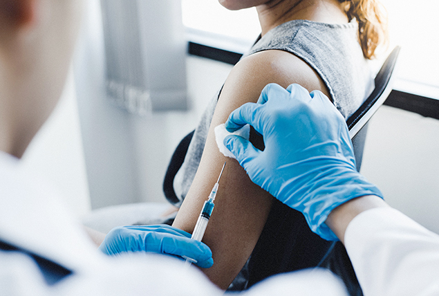 A woman gets a shot of the HPV vaccine in her left arm.