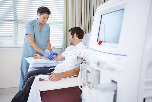 a man gets treated in a hospital with an iv by a nurse in green scrubs