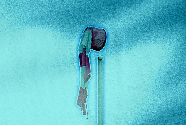 A wind sock hangs deflated on a post.