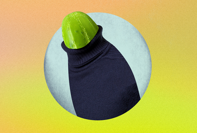 A dark purple sweater sleeve pulls down over a cucumber.