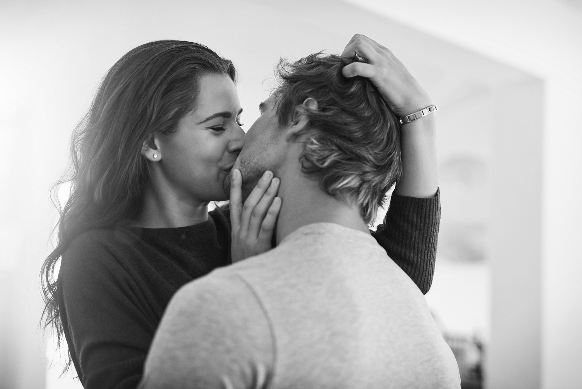 A man and woman are kissing as they embrace.