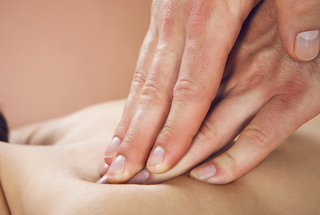 fingers massage a pressure point on someone's back