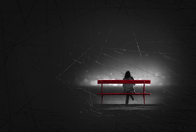 person sits on red bench alone surrounded by shadows