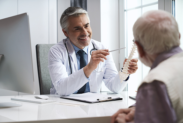 A man listens to a doctor talk about osteoperosis.