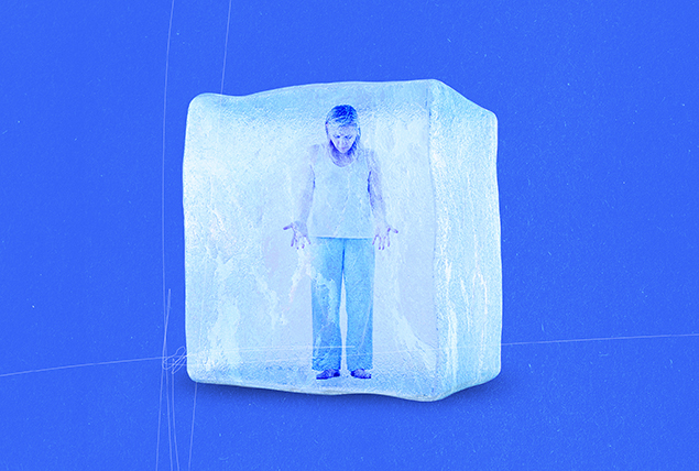 woman in plain clothes stands in giant ice cube on blue background