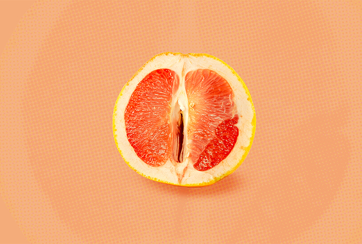 Half of a grapefruit is against an orange background.