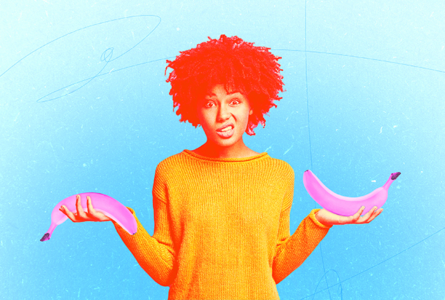 woman in yellow shirt holds two pink bananas in each hand one erect one downturned and looks confused on blue background