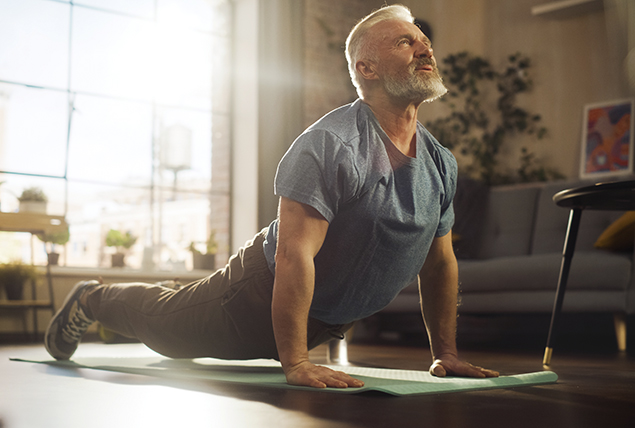 A man stretches his back during an exercise on the floor.