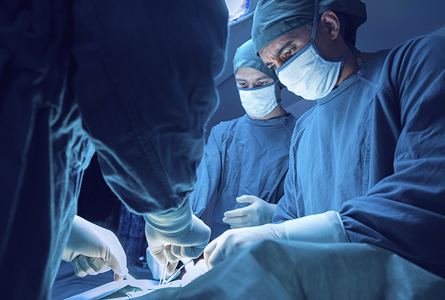 doctors in blue OR scrubs  and face masks in operating room