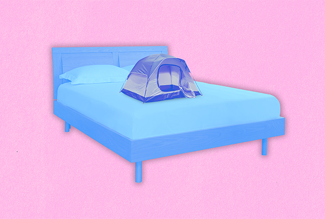 small camping tent on blue bed on pink background