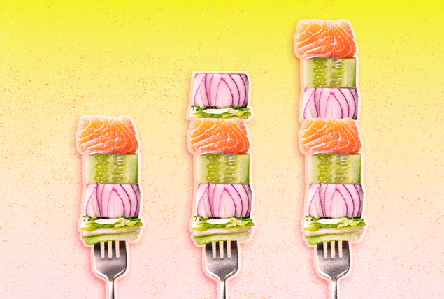 three forks with cubes of lettuce, salmon, cucumber and onion on light pink and yellow gradient background