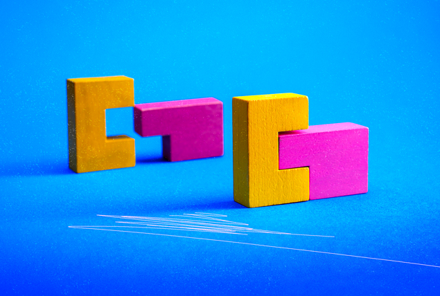multicolored building blocks fitting together on bright blue background