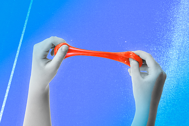 A pair of hands stretch a blob of red putty against a blue background.