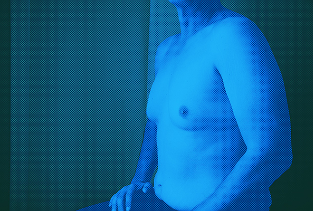 A blue light is illuminating a shirtless man.