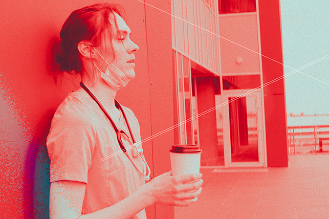 A female doctor leans against a hospital wall with her eyes closed outside while holding a cup of coffee. 