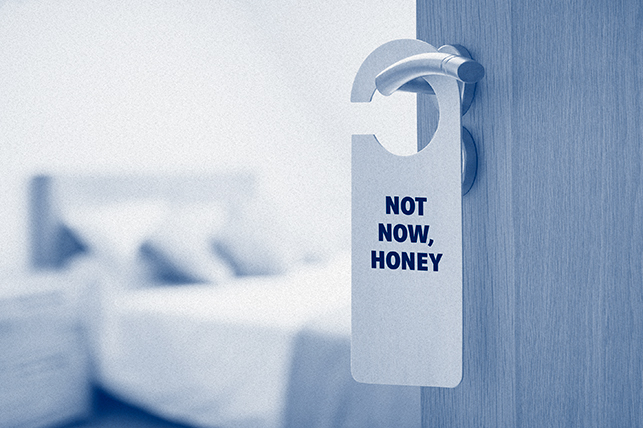 A Do Not Disturb sign on a door handle says Not Now, Honey.