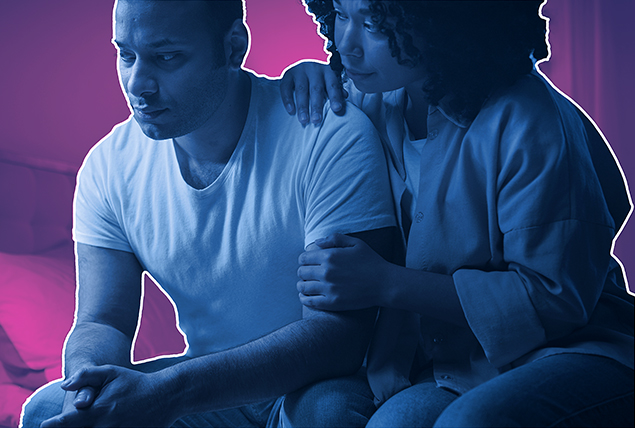 A couple sits together against a pink background.