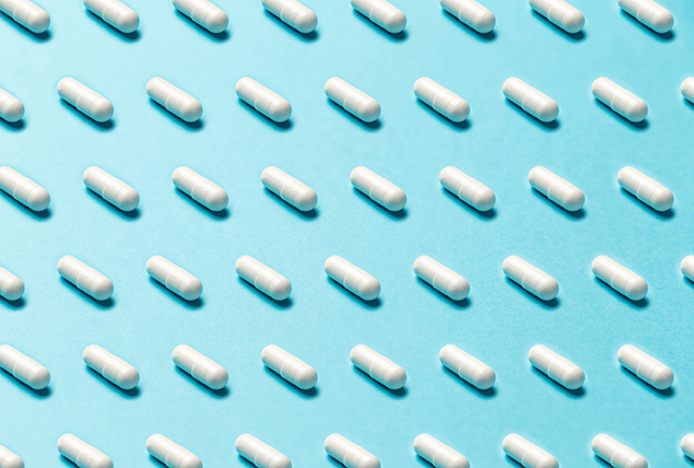 A pattern of white pills is against a light blue background.