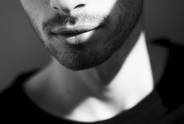 An up-close image shows the lower half of a man's face with light facial hair.