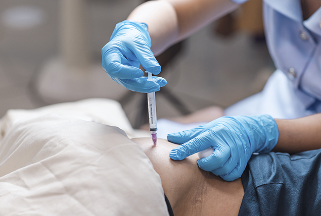 A nurse injects a person with a needle.