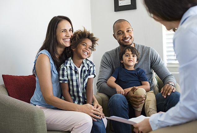 A couple holds a child in each of their laps.