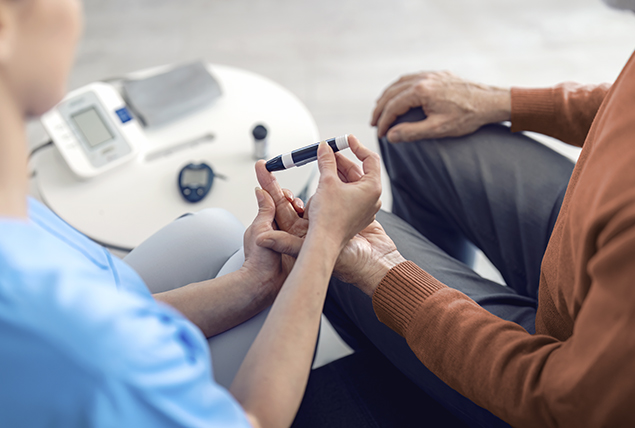 A nurse checks the blood sugar of an older patient.