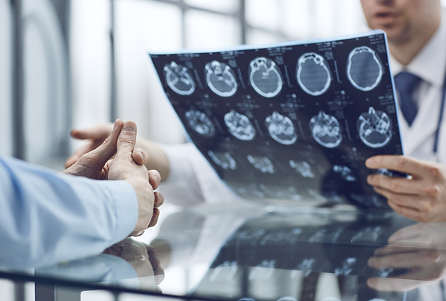 A doctor looks at an MRI scan of patient's head.