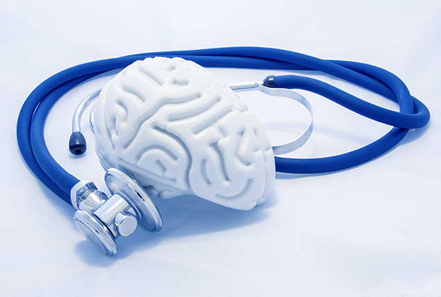 A blue stethoscope listens to greyish white brain.
