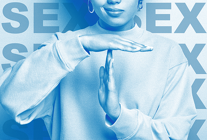 A woman holds her hands in a time out signal in front of a the word SEX repeating in blue in the background.