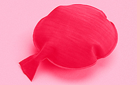 A red whoopee cushion on a pink background.