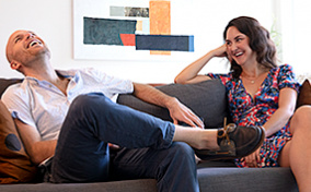 Roommates-sit-on-couch-laughing-during-date